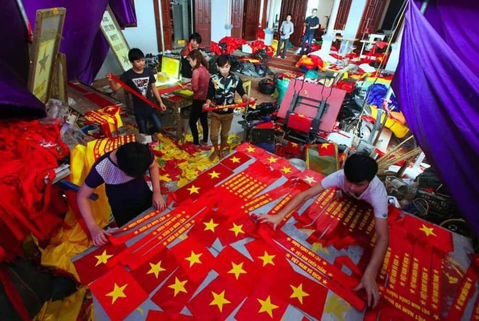Không khí tất bật chuẩn bị băng rôn, cờ đỏ sao vàng bên trong một cơ sở sản xuất. Ảnh: Facebook.