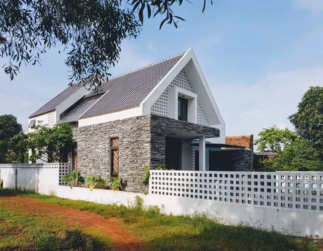 Mặt tiền ấn tượng với đá chẻ và gạch thông gió. Ảnh: Archdaily.