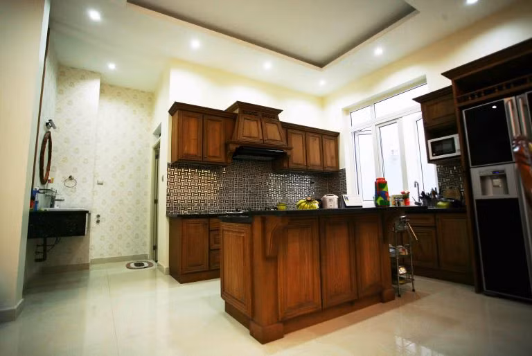 Phòng bếp tiện nghi với nội thất được làm từ gỗ tự nhiên kết hợp gam màu đỏ.