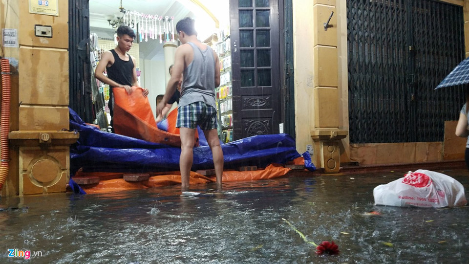 Các ngôi nhà gần khu vực Đại học Sư phạm Hà Nội, cánh đàn ông hì hục che chắn, be bờ ngăn nước tràn vào nhà.