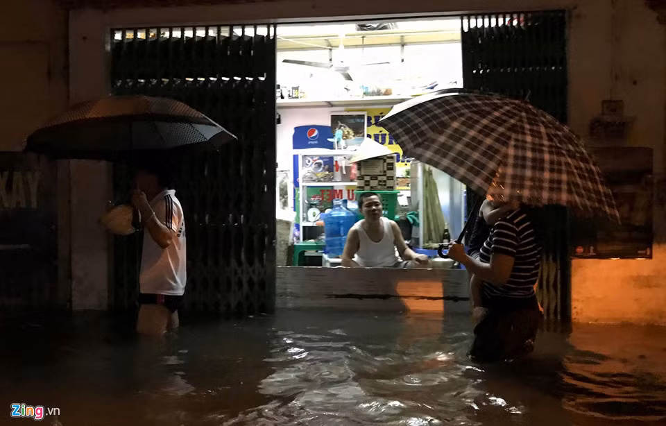 Dọc tuyến phố Hoa Bằng, hầu hết các ngôi nhà mặt đường đều bị nước tràn vào. Người dân dùng mọi biện pháp che chắn.