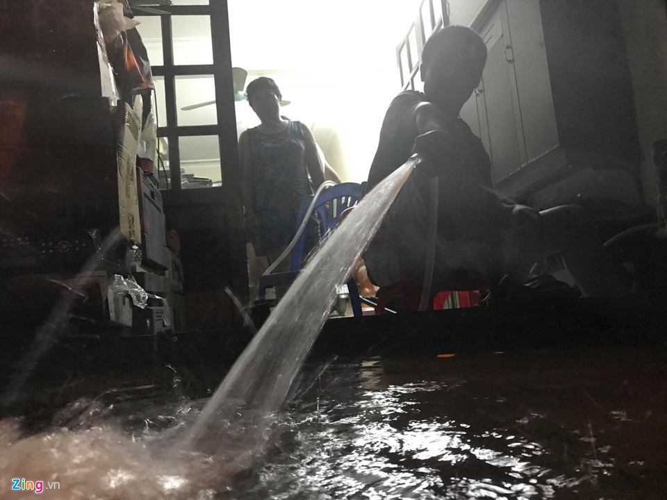 Người dân dùng máy bơm hút nước ra khỏi nhà mình trên phố Hoa Bằng, quận Cầu Giấy lúc 21h.