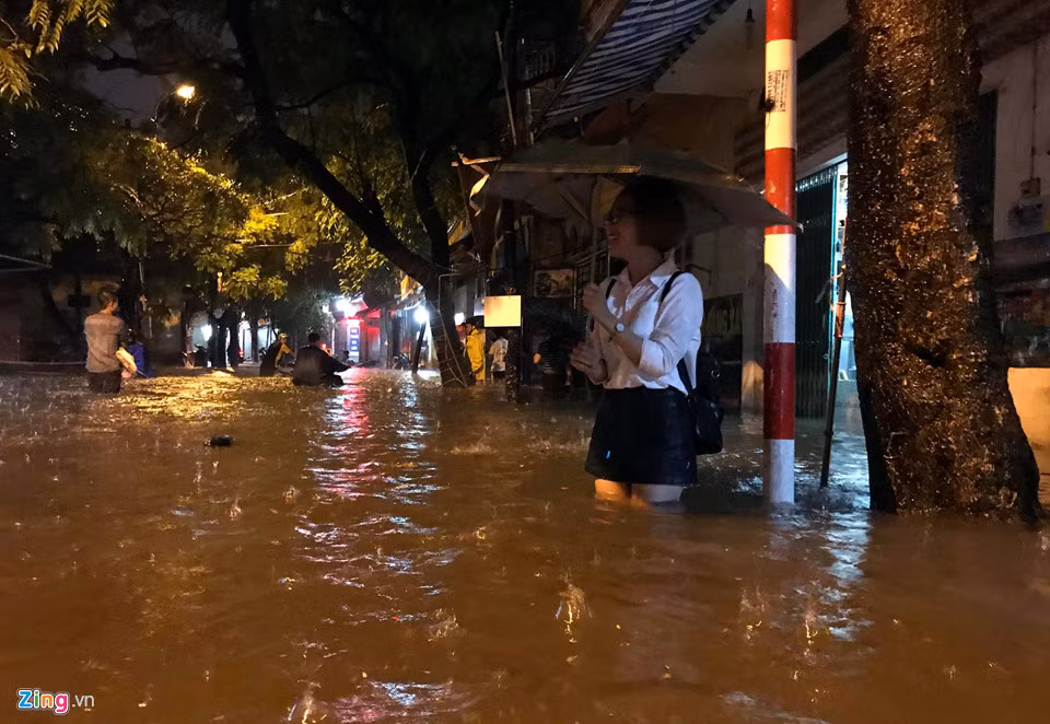 Một cô gái đứng bên lề đường sợ ướt quần áo. Cô có lời nhờ một thanh niên cõng qua đoạn ngập nhưng bị anh này từ chối vì đang bận.