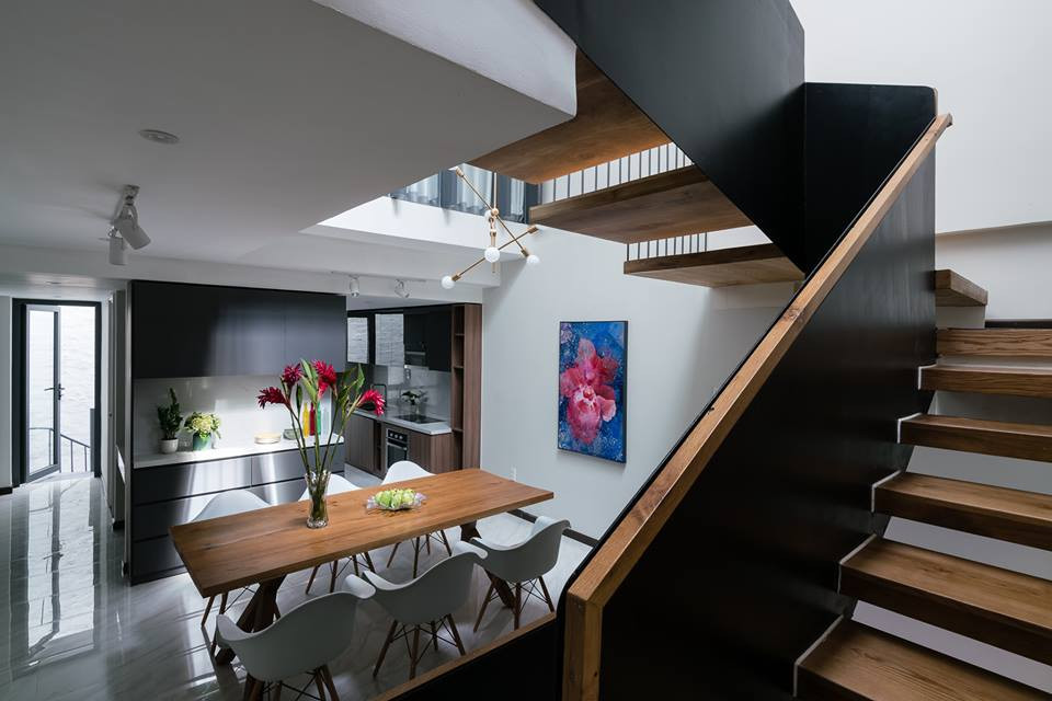 Nhà bếp, bàn ăn thiết kế gần nhau với gam màu trầm ấm.