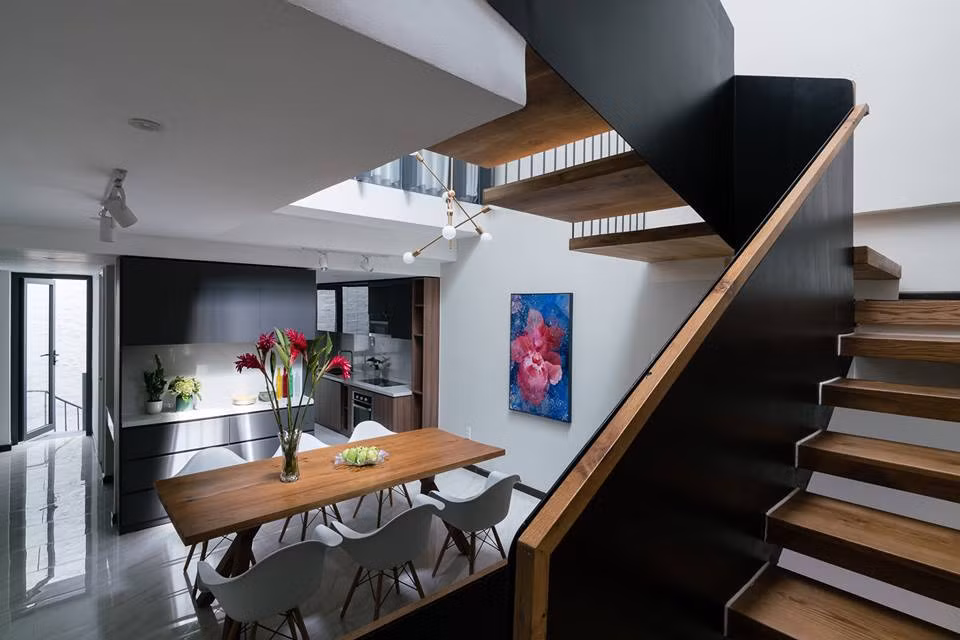 Nhà bếp, bàn ăn thiết kế gần nhau với gam màu trầm ấm.