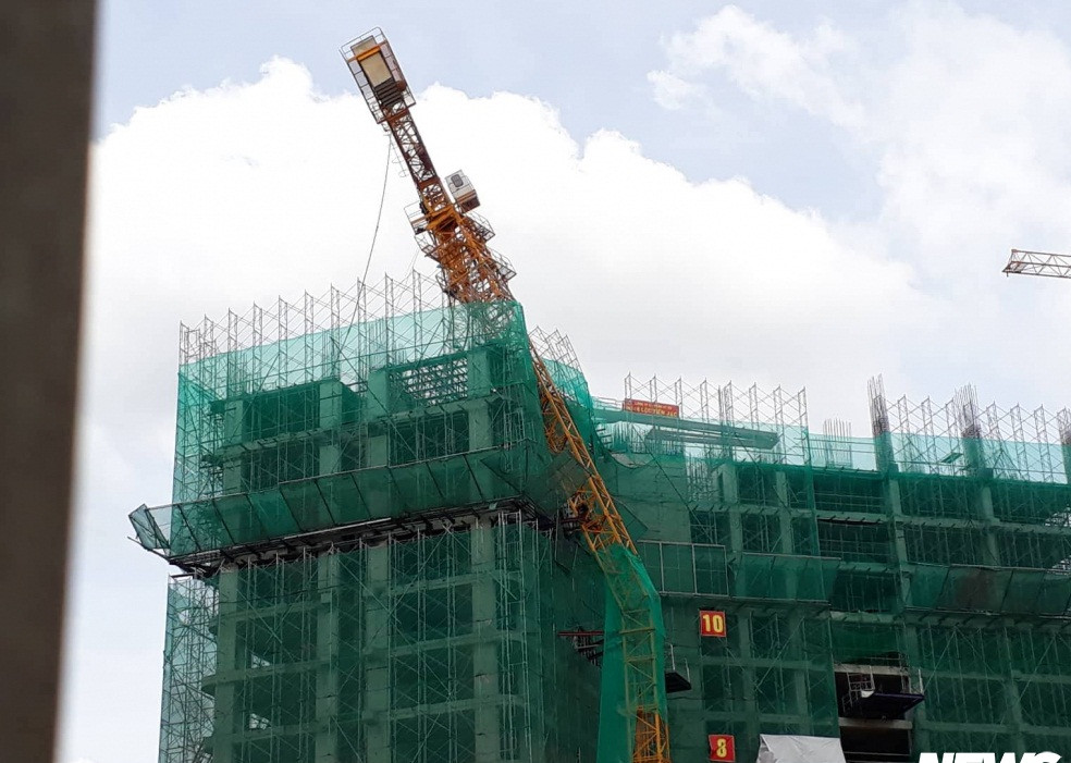 Sự việc xảy ra vào chiều 5/6. Sau tiếng ầm mạnh, người dân thấy chiếc cần cẩu cao khoảng 50m của công trình nằm lơ lửng trên tòa nhà 13 tầng đang xây bị gãy. Ảnh: VTCnews.