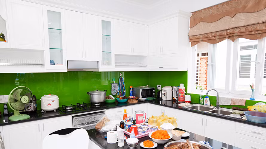 Nhà bếp tiện nghi với màu xanh nổi bật trên nền tone màu trắng.