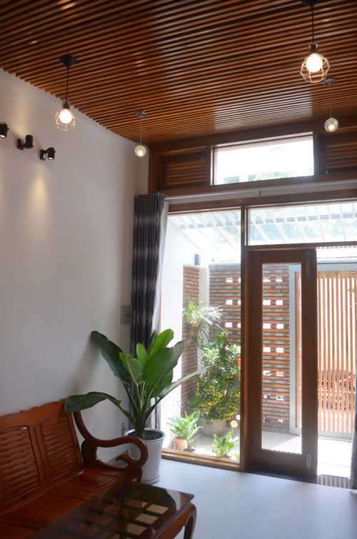 Sự giao thoa giữa mới cũ trong nhà ống 4 tầng thể hiện qua chất liệu gạch trần, gỗ mộc.