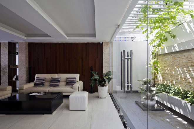 Khoảng sân sau được bố trí một hệ lam che nắng và dây leo, tăng thêm màu xanh mát.