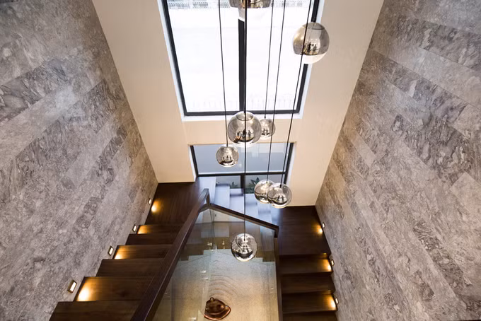 Hai bên cầu thang gỗ được ốp đã granite.