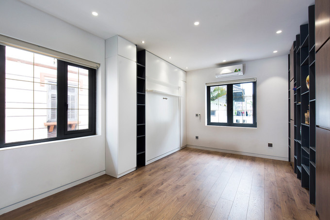 Phòng đa năng sử dụng nội thất thông minh. Chiếc giường ngủ được cất giấu khéo léo sau bức tường trắng.