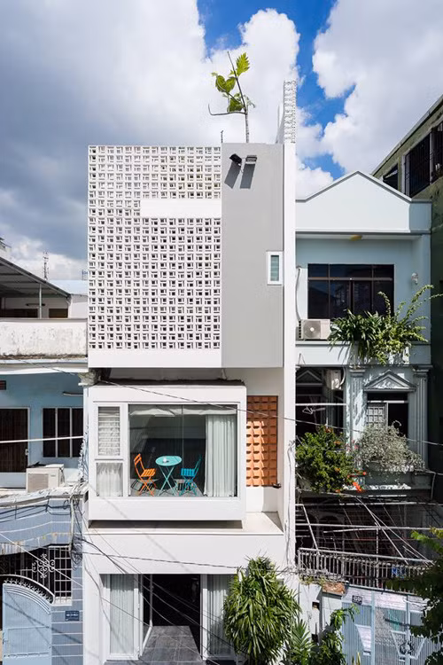 Mặt tiền là sự phối hợp hài hòa giữa gạch lỗ cùng các ô cửa kính.