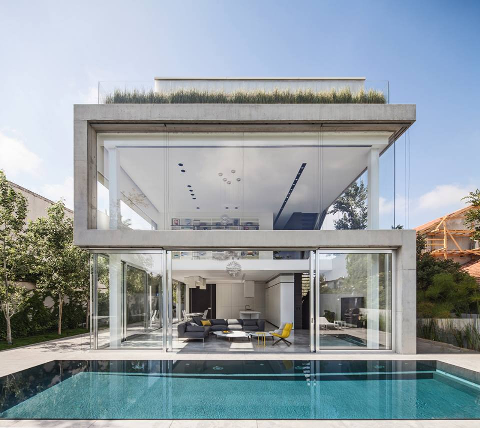 Toàn bộ hệ thống cửa của biệt thự 2 tầng được làm bằng kính trong suốt. Phía trước là bể bơi ngoài trời rộng.