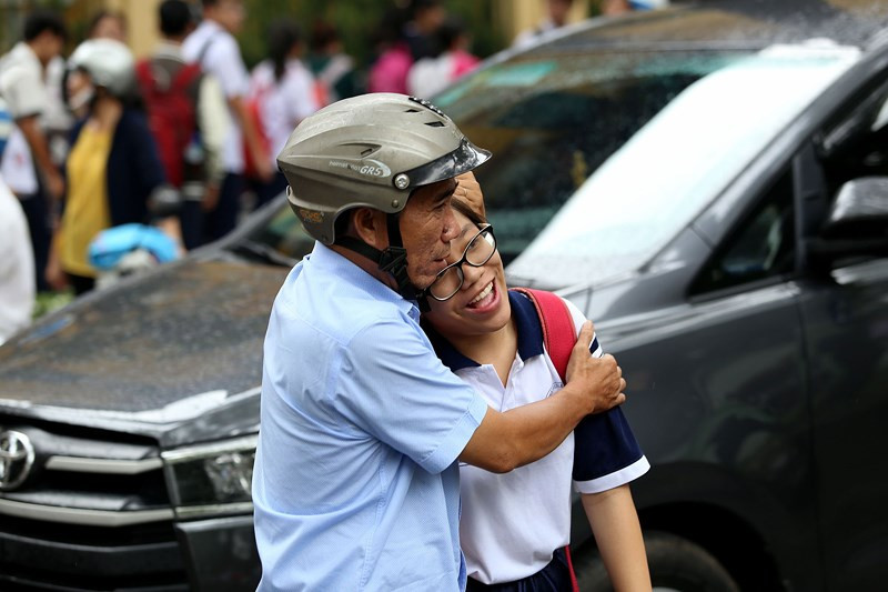 Hai bố con ôm chầm lấy nhau chúc mừng con gái làm được bài.