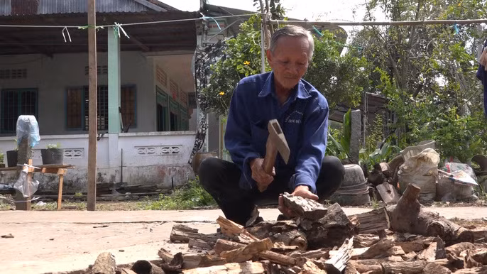 Tự tay ông chẻ củi để chuẩn bị nấu bánh tét dịp Tết cổ truyền sắp tới