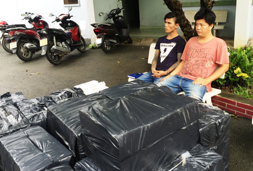 Hai đối tượng cùng tang vật là hàng chục nghìn gói thuốc lá lậu.