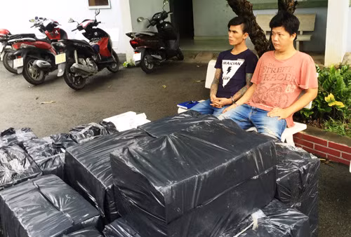 Hai đối tượng cùng tang vật là hàng chục nghìn gói thuốc lá lậu.