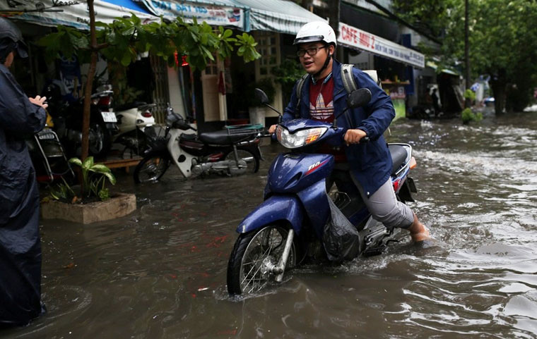Người đi xe máy bị chết máy trên đường Ung Văn Khiêm do ngập nước mưa. 