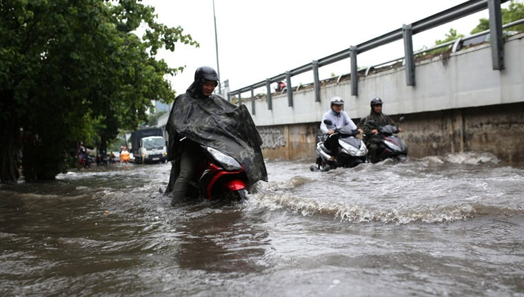 Xe máy người dân bị dòng nước xô ngã mỗi khi có ô tô, xe buýt chạy qua tạo sóng, khiến giao thông vô cùng hỗn loạn.