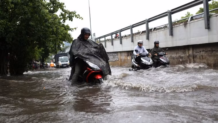 Xe máy người dân bị dòng nước xô ngã mỗi khi có ô tô, xe buýt chạy qua tạo sóng, khiến giao thông vô cùng hỗn loạn.