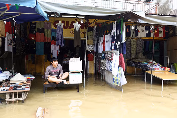 Hàng quán bắt đầu dọn khi có thông báo nước lũ tiếp tục đổ về.