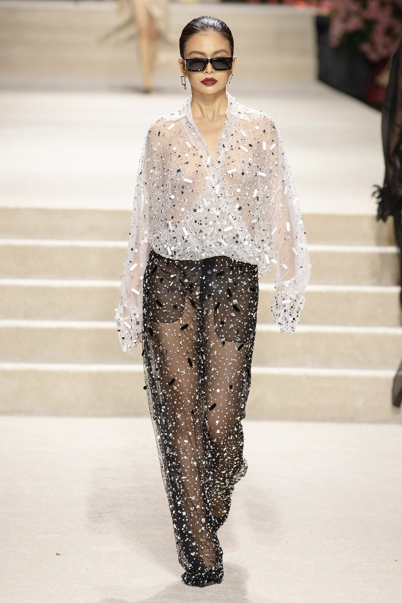 Tại đây, thời trang được giải phóng ra xa khỏi những khuôn mẫu. Vòng eo cạp trễ cùng giày đế thấp, chiếc áo vest ngoại cỡ cùng chiếc mini top thoắt ẩn thoắt hiện cũng được thêm vào BST. Thoạt nhìn, những phom áo cứng cáp với chất liệu dày dặn như đang tích cực lăng xê mốt “sang trọng thầm lặng”. Tuy nhiên, bộ váy áo sequin, kết đá lấp lánh chắc chắn làm hài lòng các quý cô mùa lễ hội cuối năm.