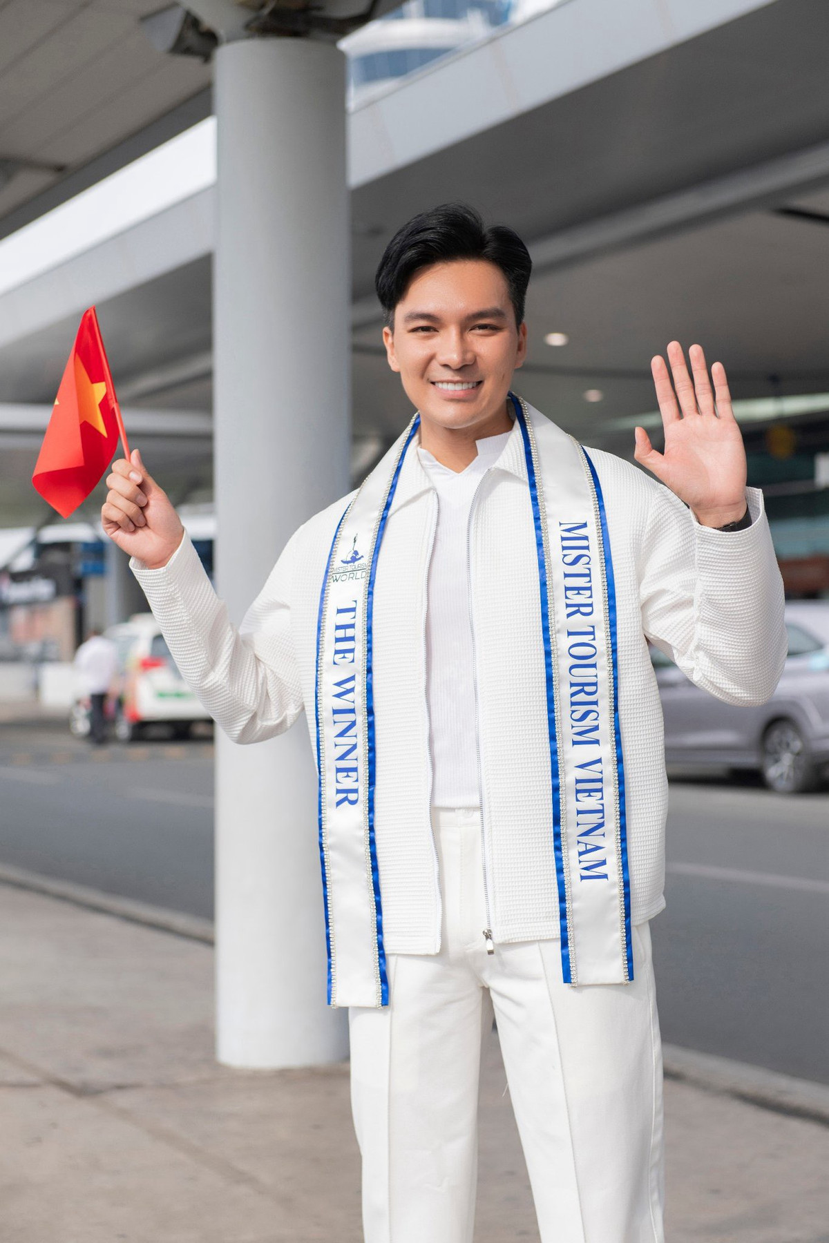 Xuất hiện ở sân bay, Quốc Trí diện cây trắng phối vest trẻ trung, bên trong mặc áo thun trắng.
