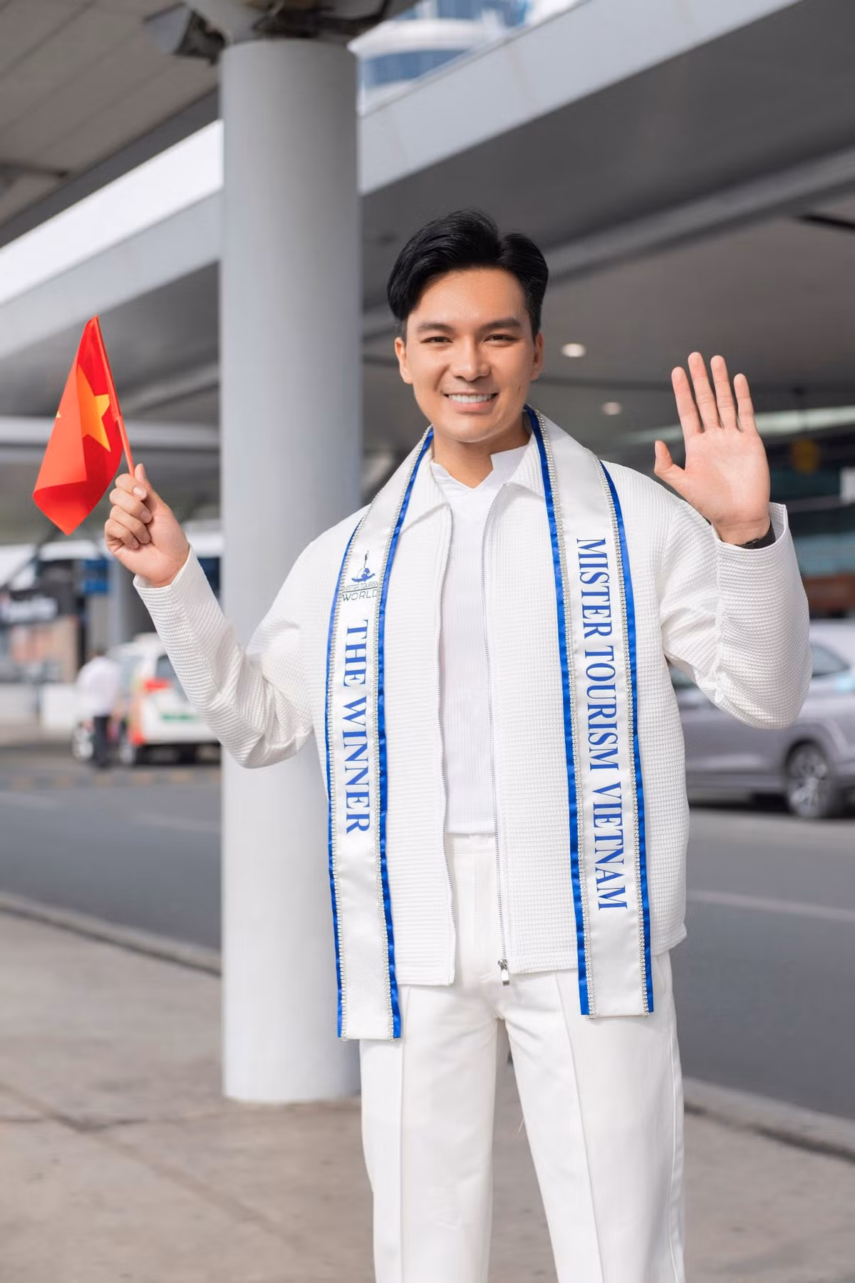 Xuất hiện ở sân bay, Quốc Trí diện cây trắng phối vest trẻ trung, bên trong mặc áo thun trắng.