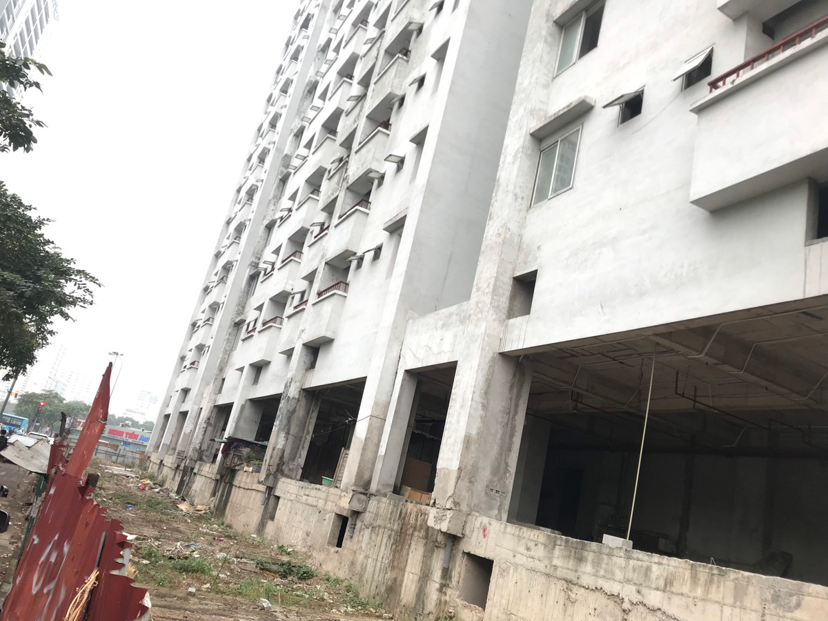 Phần hạ tầng bên trong hàng rào tôn khu nhà tái định cư vẫn chỉ là nền đất, đá, nhếch nhác.