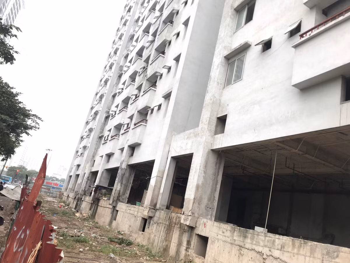 Phần hạ tầng bên trong hàng rào tôn khu nhà tái định cư vẫn chỉ là nền đất, đá, nhếch nhác.