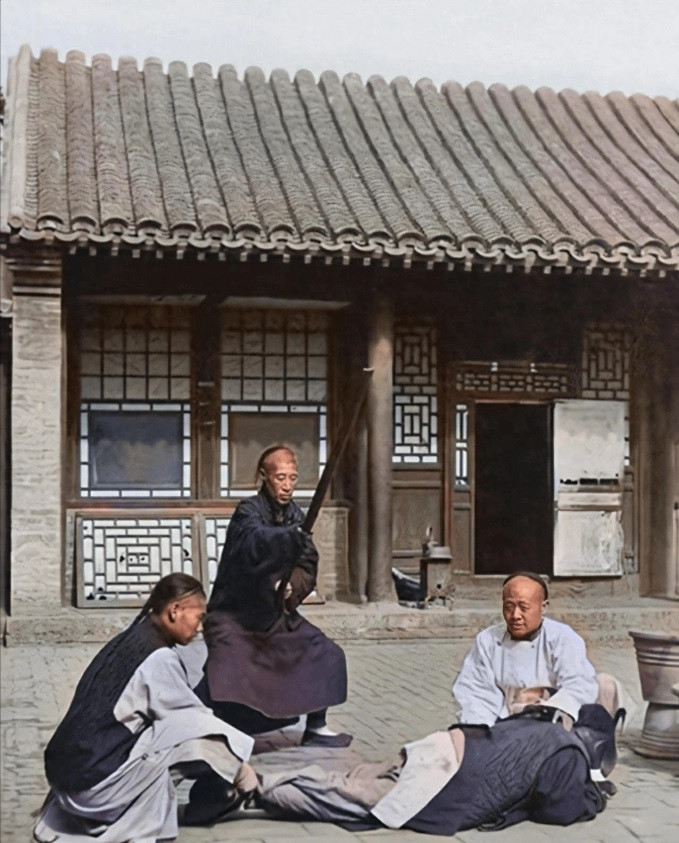 Ba nam giới thi hành án phạt đánh bằng trượng cho một phạm nhân.