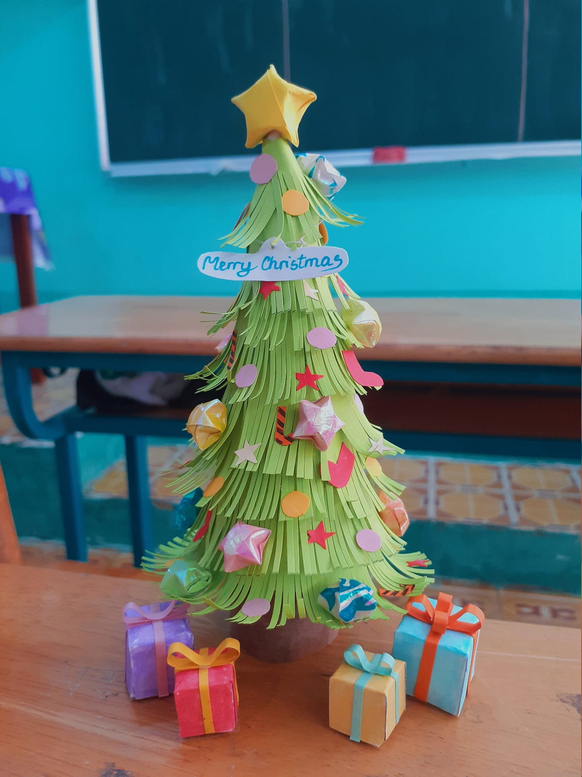 Chỉ với những nguyên vật liệu đơn giản như giấy màu, băng dính, keo dán, các em đã tạo hình cây thông nhỏ nhắn với chiều cao khoảng vài gang tay.