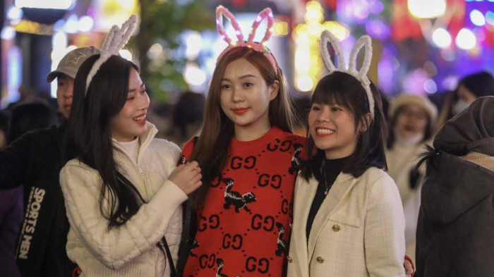 Nhiều bạn trẻ xúng xính quần áo xinh đẹp, rủ rê nhau đến check in phố đi bộ Hoàn Kiếm trước thềm chuyển giao năm mới. Ảnh: Báo Giao thông