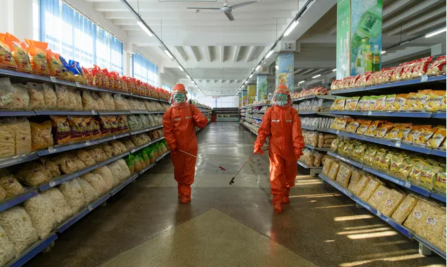 Các nhân viên phun khử trùng để phòng COVID-19 tại cửa hàng bách hóa Yokjon ở thủ đô Triều Tiên ngày 20/10/2021.