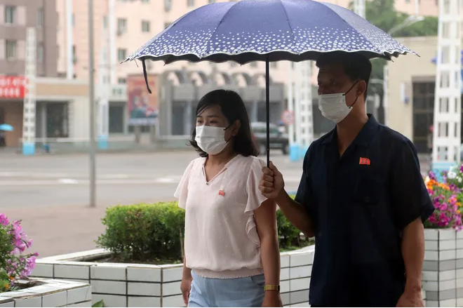 Một người đàn ông và một phụ nữ đi bộ trên con phố trước ga tàu ở Bình Nhưỡng. Bức ảnh chụp ngày 21/6/2023.