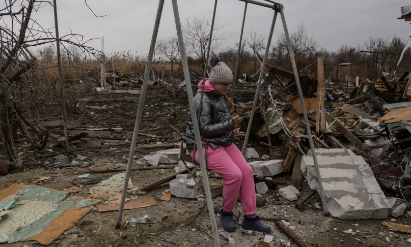 Cô gái ngồi trên xích đu tại khu dân cư bị hư hại nặng nề ở Odesa ngày 1/1.