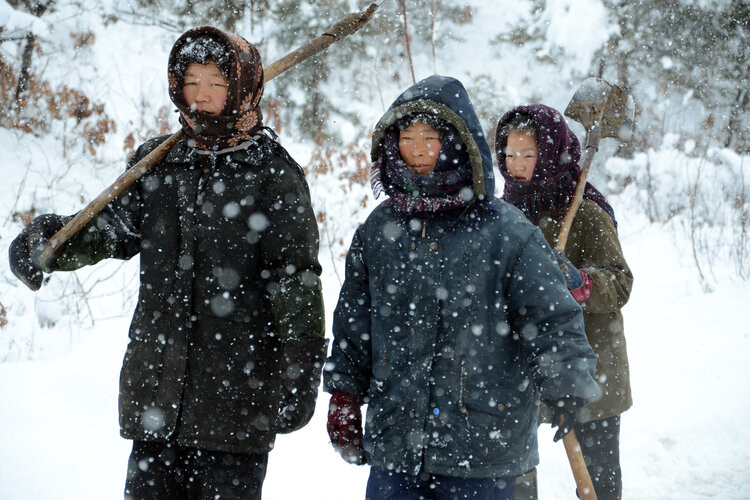 Phụ nữ ở Kowon, tỉnh Kangwon, mang theo dụng cụ để dọn tuyết trên đường sau khi nơi này hứng chịu một trận bão tuyết bất ngờ.