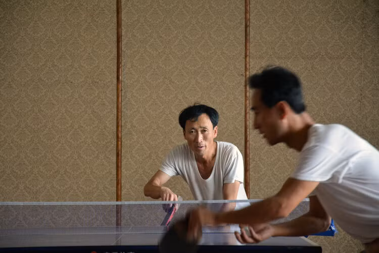 Hai người đàn ông chơi bóng bàn với nhau sau giờ làm việc ở thành phố Hamhung.
