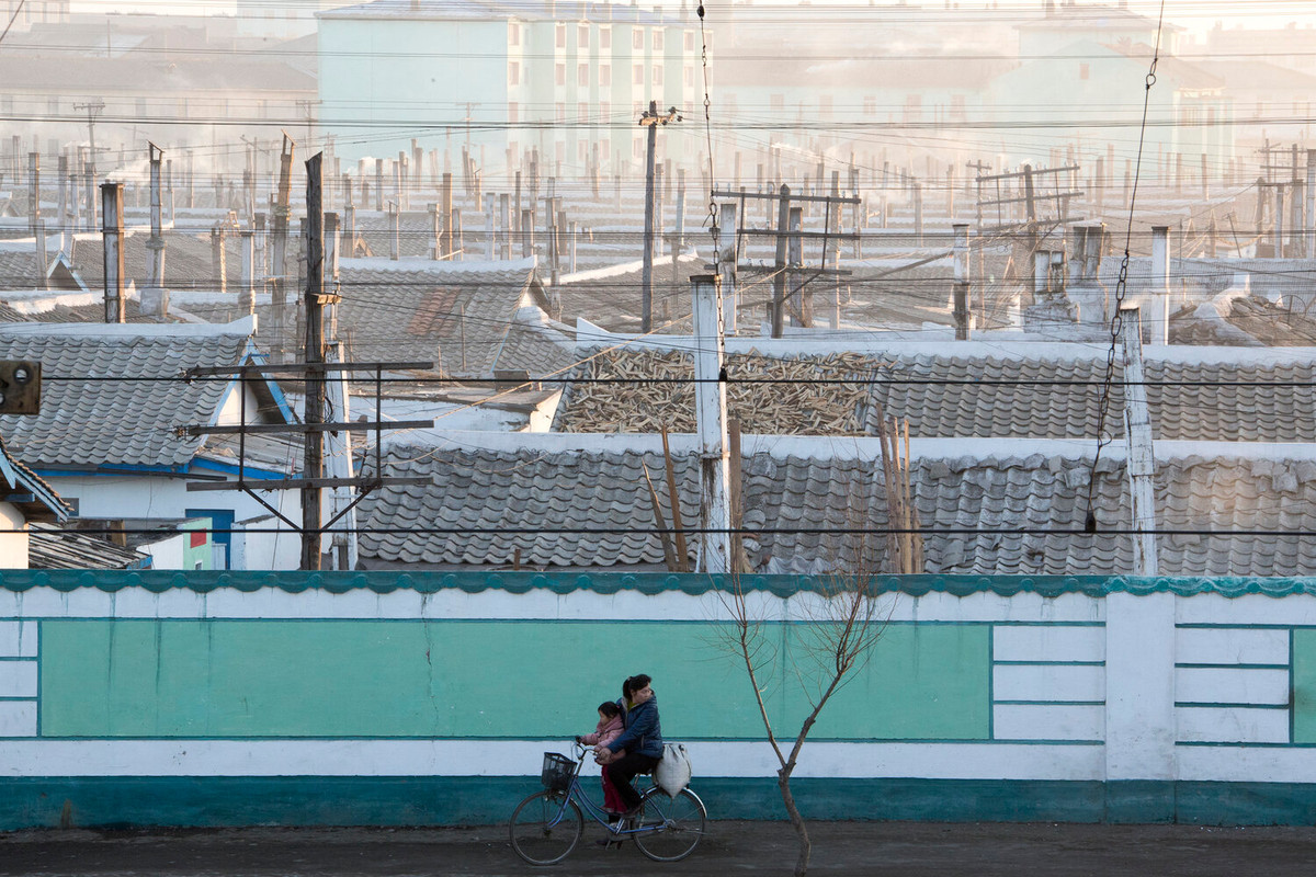 Trong ảnh, một người mẹ đạp xe cùng con gái trên con đường ở thành phố Chongjin, tỉnh Bắc Hamgyong, Triều Tiên. (Nguồn ảnh: IN)