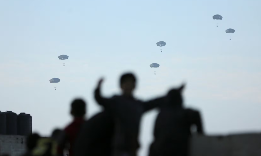 Người dân đứng nhìn khi Quân đội Mỹ thả hàng viện trợ xuống thành phố Gaza ngày 2/3. 