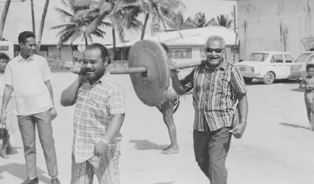 Những đồng xu nặng được vận chuyển về Yap từ Palau bằng cách khoét một lỗ ở giữa. Để di chuyển đồng xu, một cây sào chắc chắn được đưa qua lỗ này, sau đó được những người đàn ông nhấc lên và mang theo. Ảnh: Những người đàn ông khiêng đồng xu bằng đá có kích thước lớn. Ảnh: UBF. 