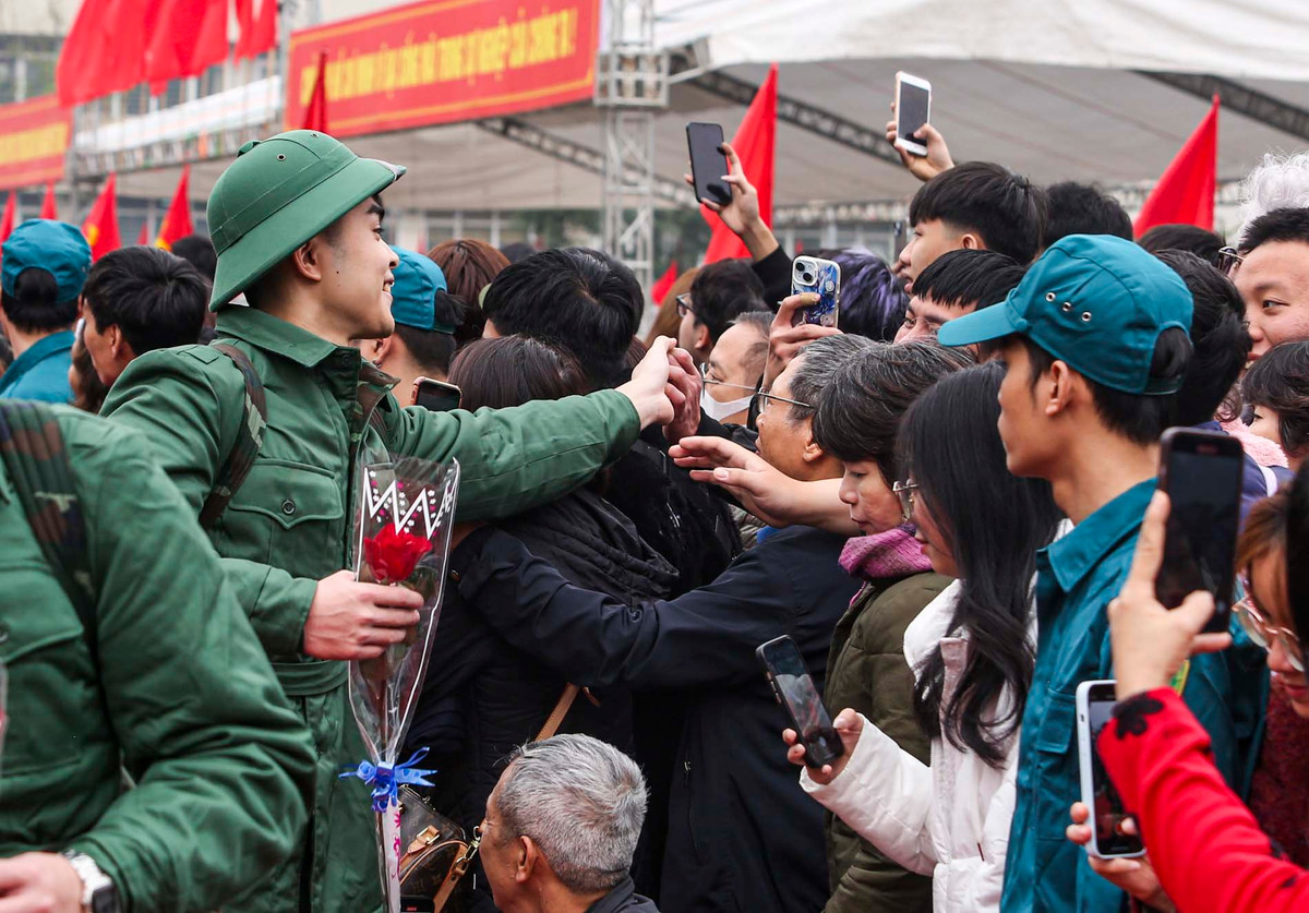 Các bạn trẻ tươi cười chào tạm biệt gia đình, bạn bè để lên đường thực hiện nghĩa vụ, đóng góp sức trẻ của mình cho đất nước. 