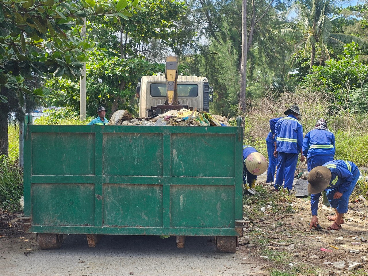 Công nhân vệ sinh môi trường đang nỗ lực thu gom rác thải dọc khu vực vịnh Mân Quang sáng 25/6.