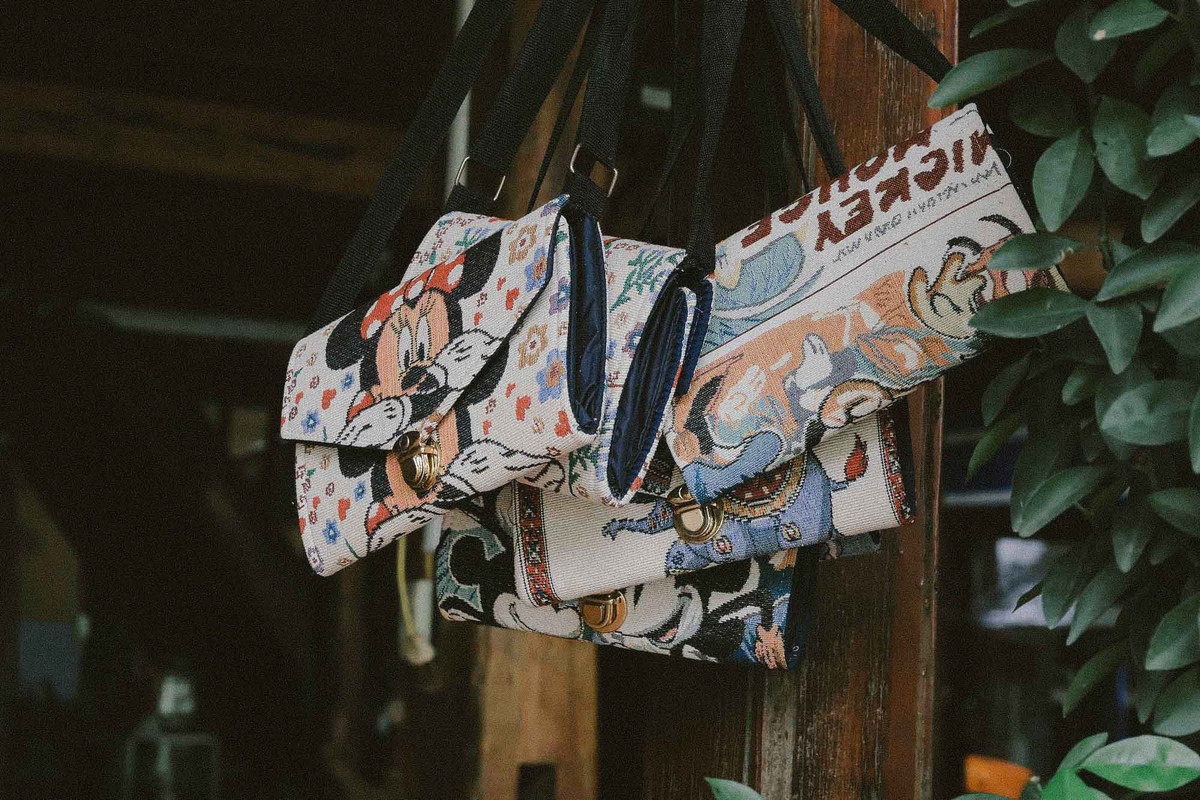 Đến bản Lác, du khách có thể mua những món quà lưu niệm như váy thổ cẩm, khăn quàng cổ, váy xòe Thái, hay những chiếc ví nhỏ xinh… Ảnh: Vương Lộc