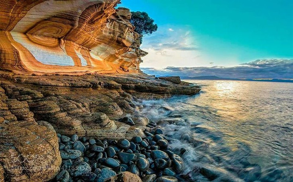 Thành tạo đá đặc biệt này được chạm khắc bởi tác động của sóng biển. Các dạng dải và vòng màu đỏ, cam và vàng do các vết nứt, các lớp có trong đá sa thạch. Ảnh: Pinterest