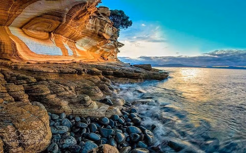 Thành tạo đá đặc biệt này được chạm khắc bởi tác động của sóng biển. Các dạng dải và vòng màu đỏ, cam và vàng do các vết nứt, các lớp có trong đá sa thạch. Ảnh: Pinterest