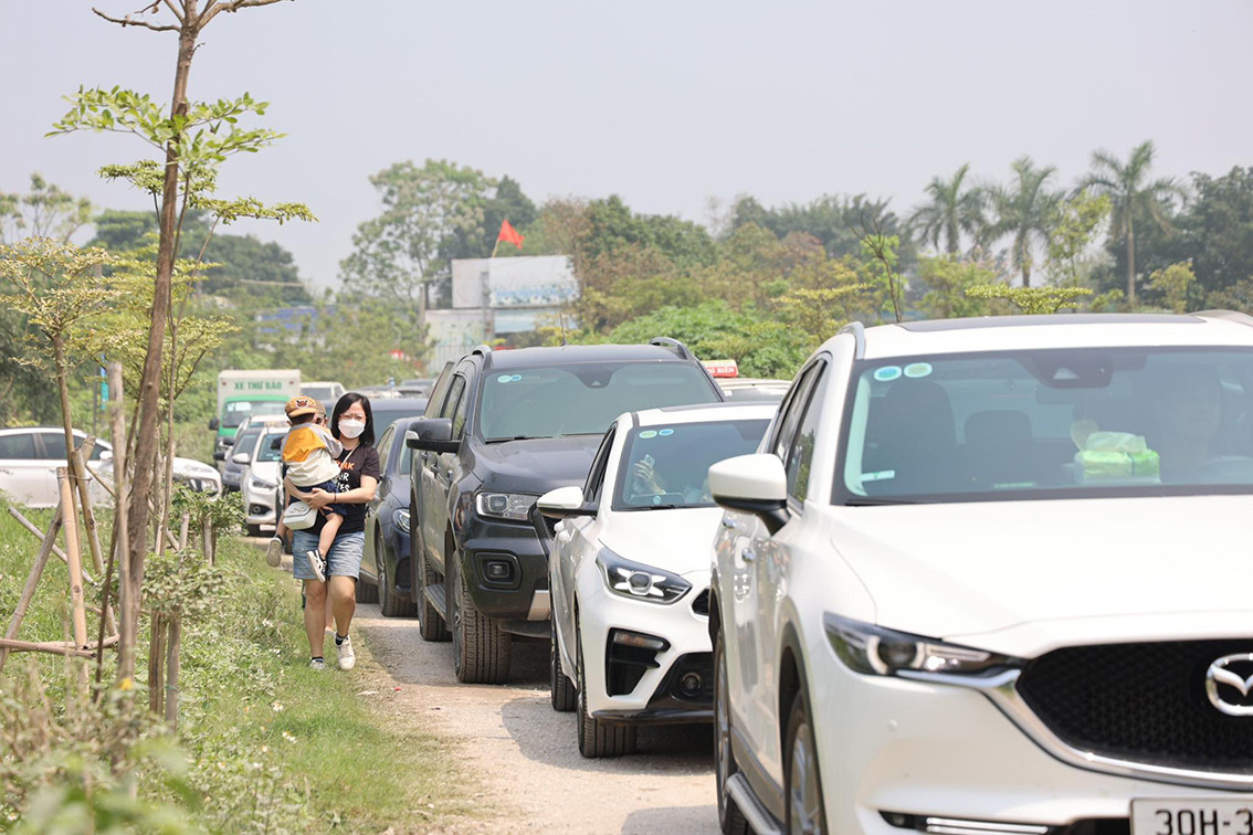 Để nhanh chóng thoát khỏi đám đông, khói bụi, nhiều gia đình đã cho con nhỏ đi bộ giữa dòng phương tiện đang xếp hàng dài.