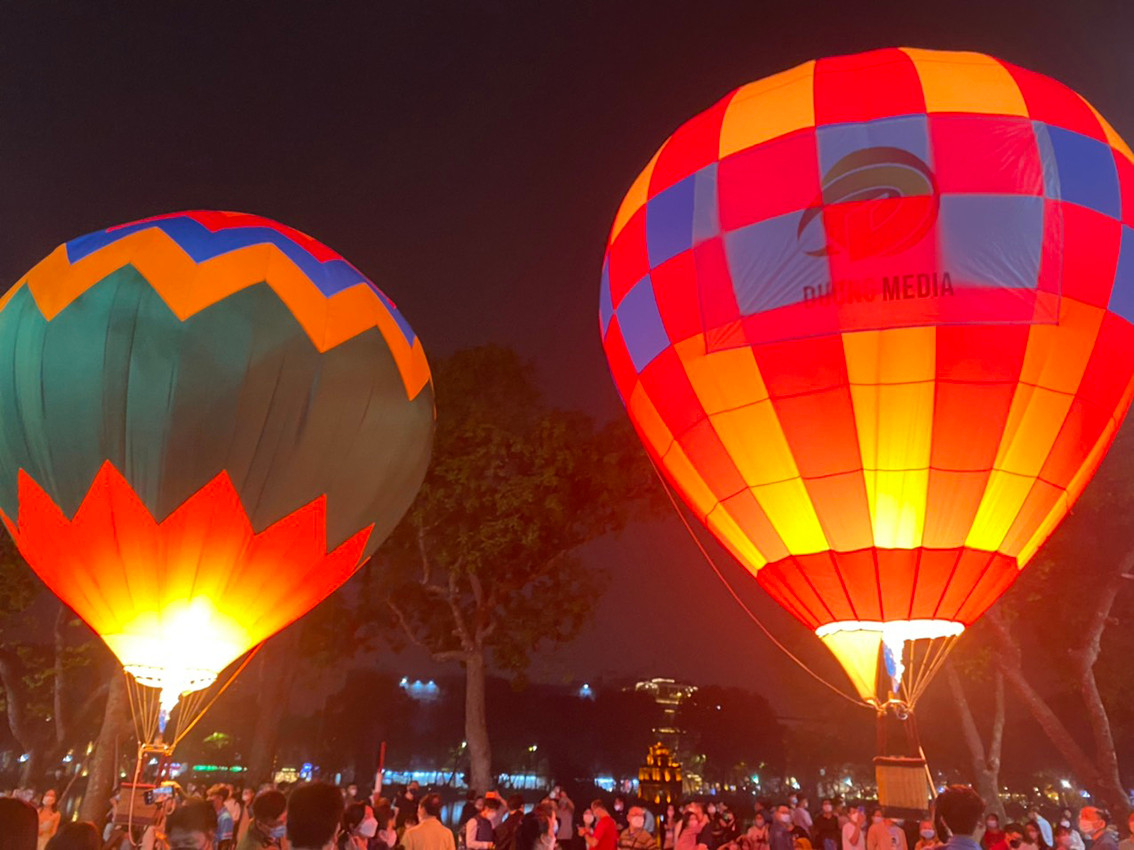 Những khinh khí cầu đầy màu sắc soi bóng càng khiến mặt Hồ Gươm thêm rực rỡ.