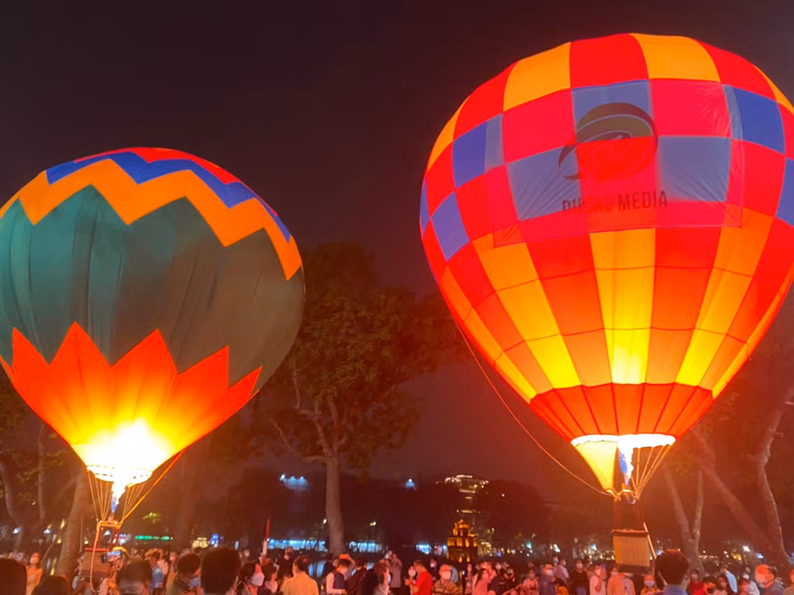 Những khinh khí cầu đầy màu sắc soi bóng càng khiến mặt Hồ Gươm thêm rực rỡ.