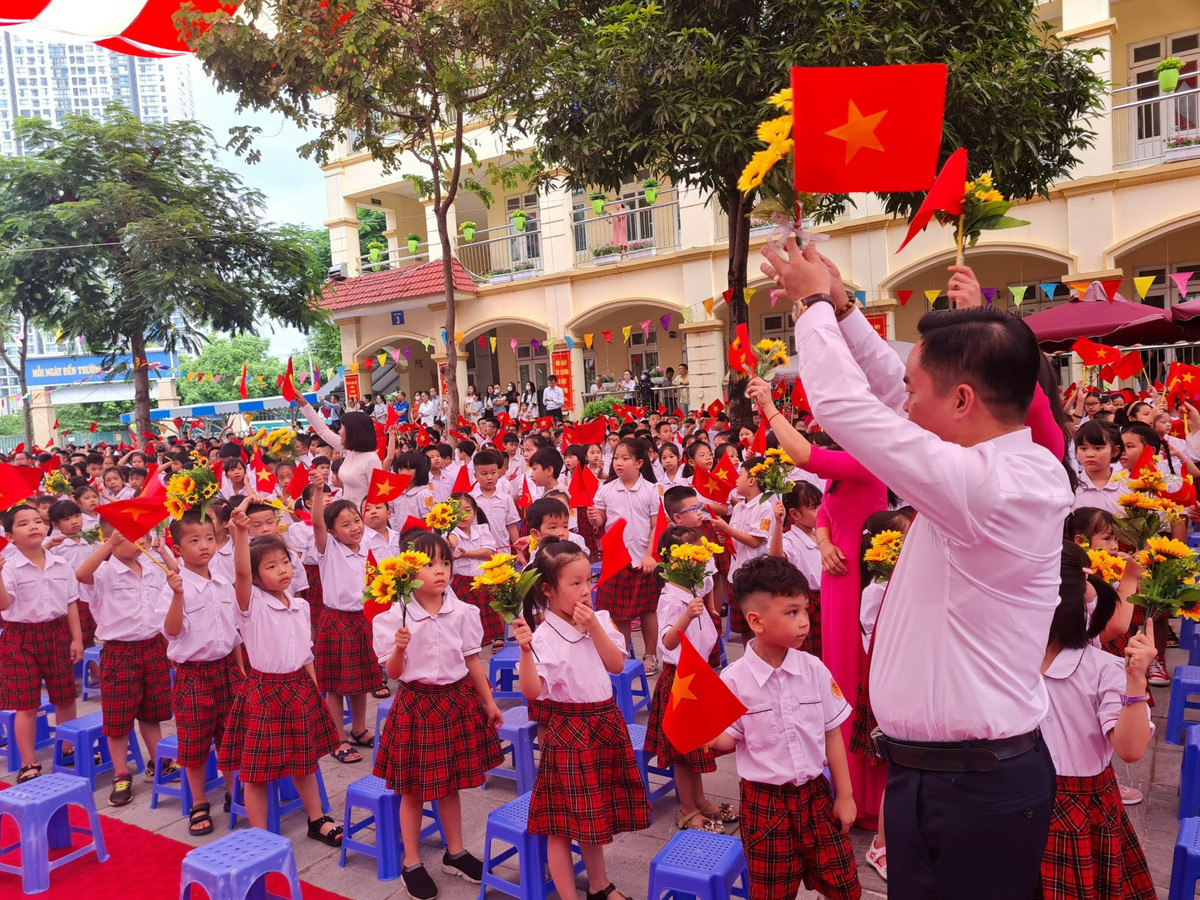 Thầy Trần Văn Hà, Hiệu trưởng Trường Tiểu học Nam Trung Yên vỗ tay đón chào các em lớp 1 trong Lễ khai giảng.